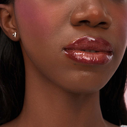 Model wearing the CHIOTURE Bronze Ember chocolate brown lip duo