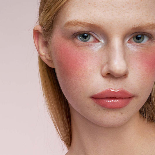 Model wearing the CHIOTURE Sunrise Beam warm nude lip duo
